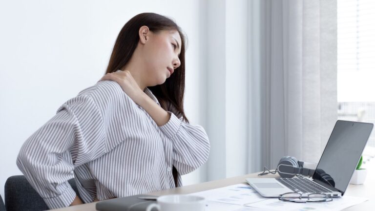 mulher com dores nas costas ergonomia